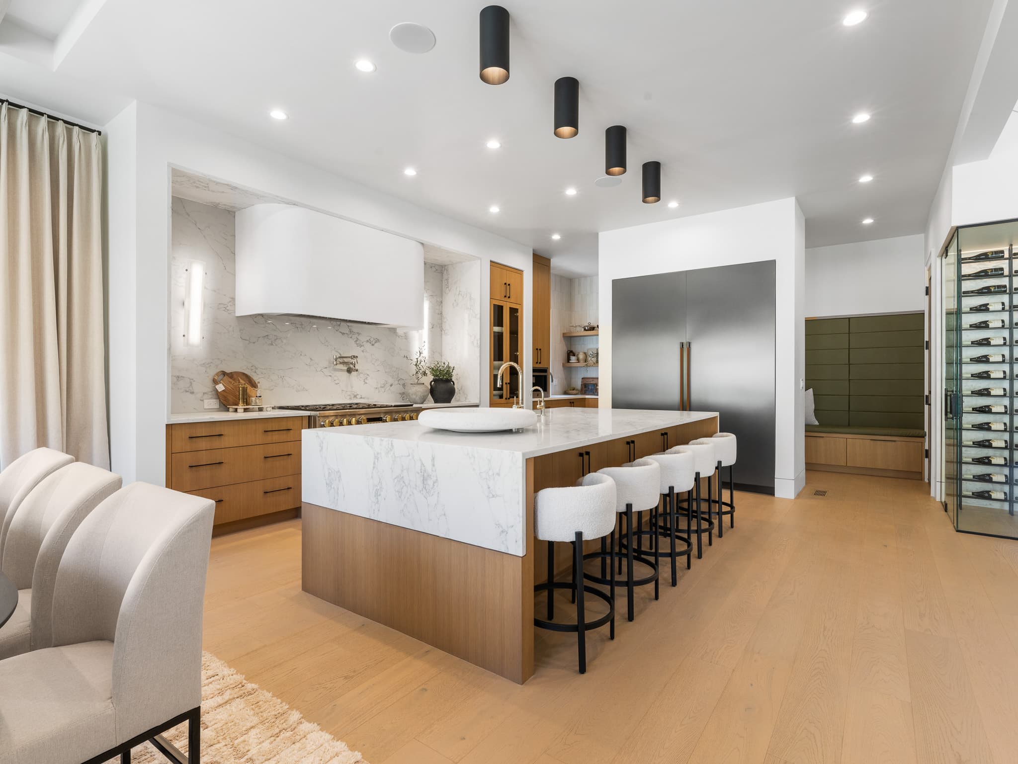 Custom kitchen remodel with a marble waterfall island, white oak cabinetry, and a professional range by Portland Tile in Portland, OR